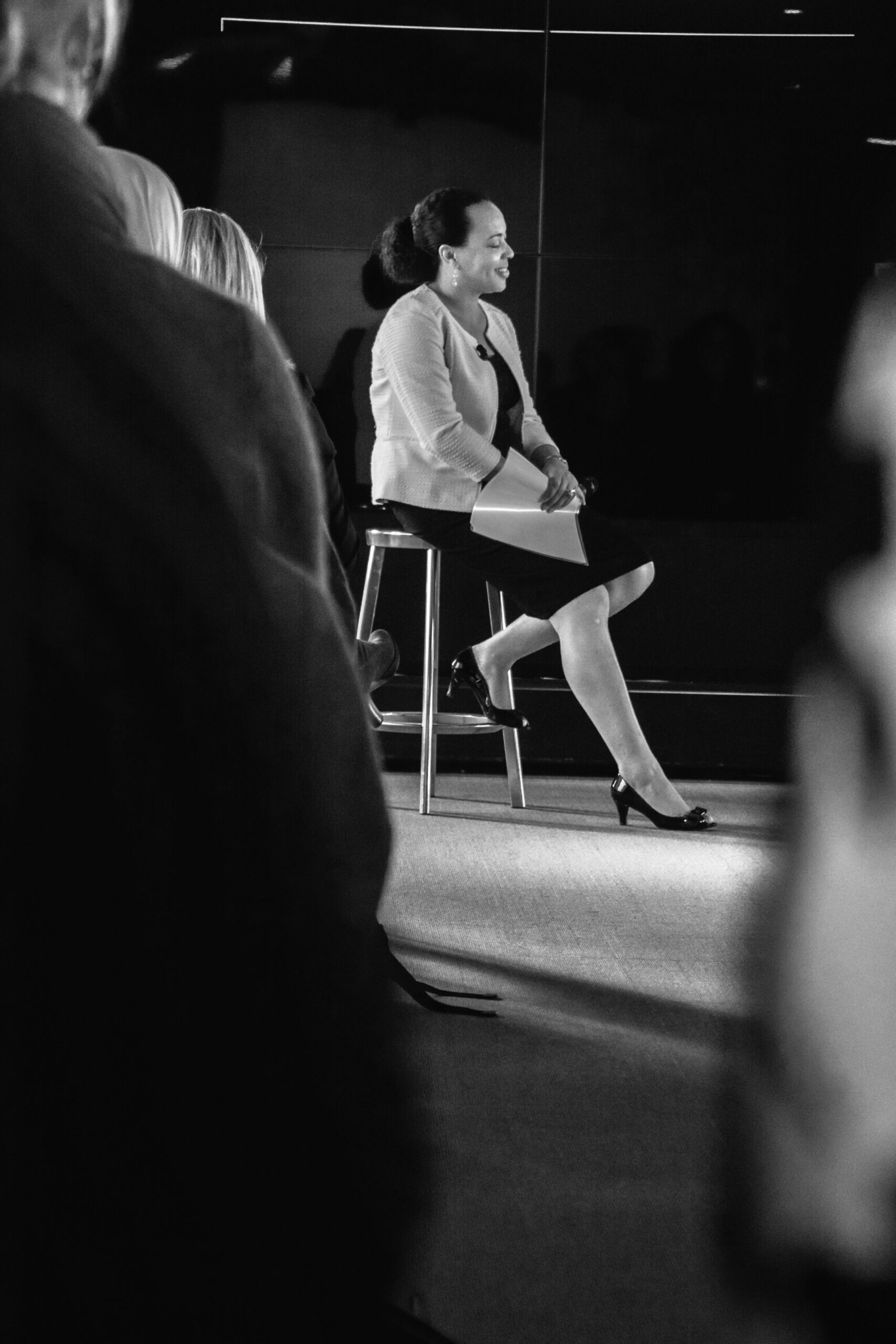 Esther speaking on stage to an audience